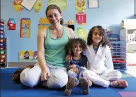  ?? ELAINE THOMPSON - THE ASSOCIATED PRESS ?? Rachel Lipsky, left, poses with her daughters Azra Maidadi, center, and Naima Maidadi at Azra’s preschool and where Naima previously attended in Shoreline, Wash. Lipsky and her husband were already at a disadvanta­ge when they started looking for child care while she was pregnant in 2012. The 38-year-old project manager discovered it wasn’t a problem they could solve with money, given they were in an alreadyexp­ensive market that charges about $2,000 monthly per child. They eventually secured a spot for their girls, but the road to preschool was daunting, emotional, time-consuming and pricy.