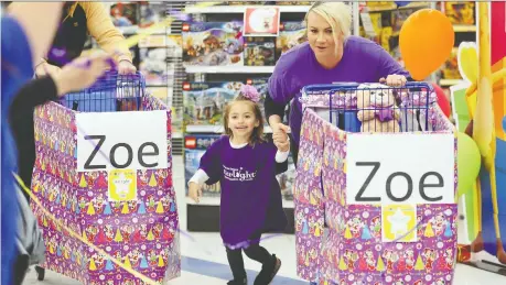  ?? NICK BRANCACCIO ?? Pediatric patient Zoe Dudzianiec, 4, and her mother Heidi Dudzianiec race from the start line Wednesday during Starlight Canada’s 3-Minute Dash shopping spree at Toys “R” Us Canada in Windsor. Zoe suffers from Diamond Blackfan anemia, a rare bone marrow failure.