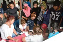  ??  ?? PHUKET: This picture shows Jiranuch Trirat, center, touching the face of her 11month-old daughter, who was killed by Trirat’s husband, after picking her body at the morgue in Phuket. — AFP