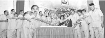  ??  ?? Pairin (middle) and Ongkili lead other PBS leaders in the joint cake cutting ceremony to mark the party’s 34th anniversar­y in Tambunan on Tuesday.