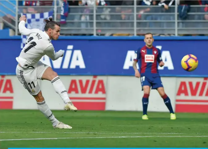  ??  ?? EIBAR: Real Madrid’s Welsh forward Gareth Bale (L) shots the ball during the Spanish league football match between SD Eibar and Real Madrid CF at the Ipurua stadium in Eibar yesterday. —AFP