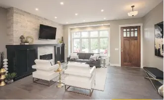  ??  ?? A horizontal fireplace encased in a floor-to-ceiling surround faced with brick tile anchors the great room.