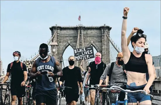  ?? ANGELA WEISS / AFP ?? Jóvenes manifestan­tes marchando sobre el puente de Brooklyn, en la ciudad de Nueva York, el pasado jueves