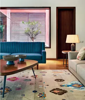  ?? ?? LIVE IN LUXE
Another view of the living room with the custom hand knotted carpet by Jaipur Rugs (above); the outdoors (left); the water feature with a red backdrop (top right); another living space (below right)