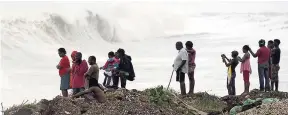  ?? FILE ?? In this October 2016 photo, residents of Kingston watch the waves build as Hurricane Matthew approached the island.