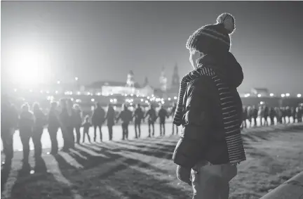  ??  SEAN GALLUP/GETTY IMAGES ?? People link hands Friday as they stand along the Elbe River, across from Dresden’s historic city centre, to commemorat­e the 70th anniversar­y of the Allied firebombin­g of the city by U.S. and British forces. An estimated 25,000 people were killed.