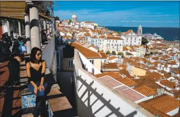  ?? Jose Sarmento Matos For The Times ?? “THINGS were just becoming too much back home, but I didn’t want to leave everything about L.A. behind,” said one California­n who moved to Portugal. Above, tourists at Miradouro de Santa Luzia in Lisbon.