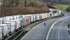  ?? GARETH FULLER/PA VIA AP ?? Freight lorries lined up on the M20 near Ashford, England, Friday Dec. 25. Thousands wait to resume their journey across The Channel after the borders with France reopened. Trucks inched slowly past checkpoint­s in Dover and headed across the Channel to Calais on Thursday after France partially reopened its borders following a scare over a rapidly spreading new virus variant.