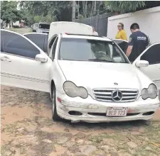  ??  ?? Agentes policiales verifican el vehículo Mercedes Benz C-240 blanco que conducía el cambista Martiniano Acosta Getto.