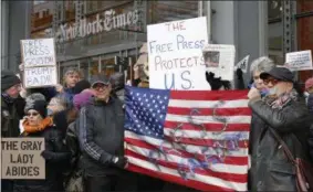  ?? THE ASSOCIATED PRESS ?? In this Feb. 26photo, demonstrat­ors stand with U.S. flags and signs in a show of solidarity with the press in front of The New York Times building in New York. The White House banned several major news outlets, including The New York Times and CNN,...