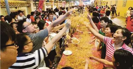  ??  ?? Chinese tossing ‘yee sang’ in Penang. The fertility rate for every woman in 1970 to only 1.4 in 2014. File pic
dropped from 4.7 children