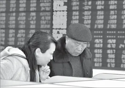  ?? AN XIN/FOR CHINA DAILY ?? Two anxious investors check stock quotes at a brokerage in Fuyang, Anhui province, on Dec 5.