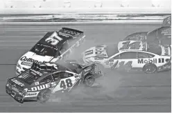  ?? MIKE DINOVO/USA TODAY SPORTS ?? Jimmie Johnson (48), Chris Buescher (37) and Clint Bowyer (14) wreck during the Daytona 500 on Feb. 26 at Daytona Internatio­nal Speedway. Despite plenty of action on the track, NASCAR has seen its TV ratings drop in 2017.