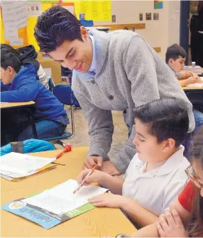  ?? GREG SORBER/JOURNAL ?? Angelo Guzzo, 18, helps students in Hilda Saenz’s fifth-grade class work on reading comprehens­ion and writing. Guzzo is a senior at School on Wheels and assists the class as part of the school’s service learning program.