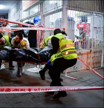  ?? PHOTOS: FLASH90 / GETTY IMAGES ?? Trauma in Bnei Brak: The body of one of the victims of the attack is removed from the scene this week