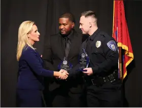  ?? (Arkansas Democrat-Gazette/Thomas Metthe) ?? Attorney General Leslie Rutledge (left) hands out awards to Hot Springs police officers James Moore (center) and Stephen Parrott (right) during the 2022 Law Enforcemen­t Officer of the Year awards on Tuesday at the Benton Events Center in Benton. Moore and Parrott along with Fort Smith officer Robin Gaines were named as the 2022 Law Enforcemen­t Officers of the Year during the ceremony.