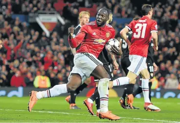  ?? /AFP ?? Too little, too late: Romelu Lukaku rushes back to the centre spot after scoring a late goal for Manchester United against Sevilla, but it was too late and United were bundled out of the Uefa Champions League.