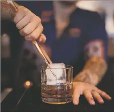  ?? COURTESY PHOTO ?? A Rolling Still bartender places a cube of ice in a glass of Ponderosa brand whiskey.