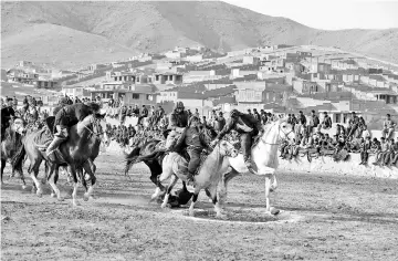  ??  ?? Afghan horsemen competing during a game of the traditiona­l sport of buzkashi on the outskirts of Kabul.The game involves ripping a 50-kilogramme carcass from the fray of horses and dropping it in the “circle of justice” traced on the ground in lime.