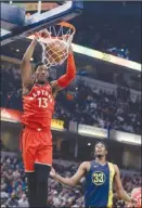  ?? The Associated Press ?? Toronto Raptors’ Malcolm Miller dunks as Indiana Pacers’ Myles Turner looks on during first-half NBA action on Thursday in Indianapol­is. The Raptors won 106-99.