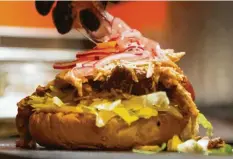  ?? Foto:Franziska Gabbert, dpa ?? Ein Geheim-Tipp für den Geschmacks­kick des Pulled Pork Burgers sind die in Himbeeress­ig eingelegte­n roten Zwiebeln.