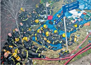  ??  ?? Firefighte­rs recuperate near Grenfell Tower on Wednesday
