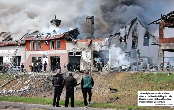  ?? Joe Raedle/Getty Images ?? Firefighte­rs battle a blaze after a civilian building in Lviv, Ukraine, was hit by a Russian missile strike yesterday