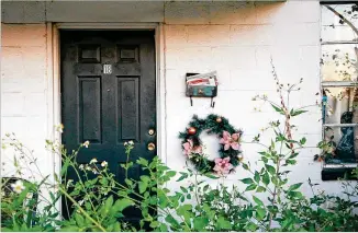  ?? RICHARD BURKHART/SAVANNAH MORNING NEWS ?? A full mailbox and a wreath remain at an apartment behind weeds at Clearview in West Savannah. Tenants got move-out notices in August, which gave 60 days to vacate apartments many called home for decades. By Dec. 22, there were three left: two with disabiliti­es and one with pets.