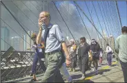  ?? (AP/Mark Lennihan) ?? People walk over New York’s Brooklyn Bridge from Manhattan to Brooklyn following the collapse of both World Trade Center towers on Sept. 11, 2001.