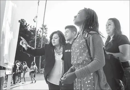  ?? Irfan Khan Los Angeles Times ?? PARENTS AND STUDENTS look for classroom assignment­s at Dodson Middle School, one of more than 1,000 L.A. Unified School District campuses to begin their school year on Tuesday. Dodson has acted to encourage more parental involvemen­t this school year.