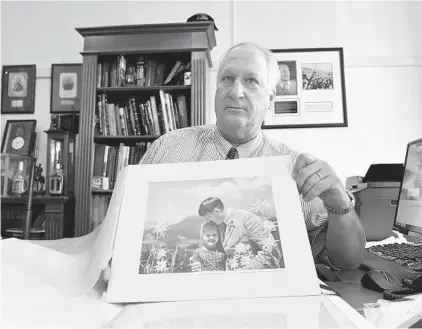  ?? EILEEN BLASS/WASHINGTON POST PHOTOS ?? “Bill” Panagopulo­s displays the 1933 Heinrich Hoffmann photograph of Hitler with Rosa Bernile Nienau known as “the Fuhrer’s child.”