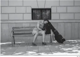  ?? M. H. ?? Un músico duerme en un banco de la calle.