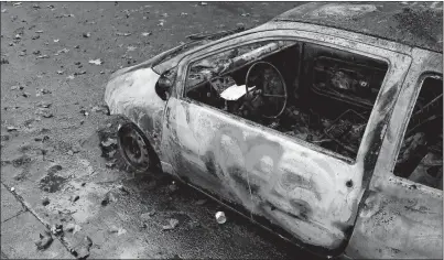  ?? THIBAULT CAMUS AP PHOTO ?? A charred car is pictured Sunday, the day after a demonstrat­ion near the Arc de Triomphe in Paris. A protest against rising taxes and the high cost of living turned into a riot in the French capital, as activists torched cars, smashed windows, looted stores and tagged the Arc de Triomphe with graffiti. More than 100 people were injured and more than 400 arrested.