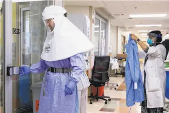  ?? Jessica Christian / The Chronicle ?? Registered nurse Ryan Sabbatini (left) wears a powered air purifying respirator in the intensive care unit as Dr. Deepa Rathi gears up at Good Samaritan Hospital in San Jose in July.