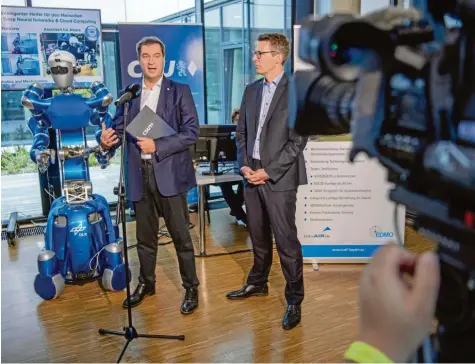  ?? Foto: Lino Mirgeler, dpa ?? Roboter „Justin“, CSU-Chef Markus Söder und Generalsek­retär Markus Blume beim Auftakt der Klausurtag­ung des CSU-Parteivors­tands.