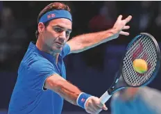  ?? AP ?? ■ Roger Federer returns to Dominic Thiem during their ATP Finals match at The O2 Arena in London on Tuesday.