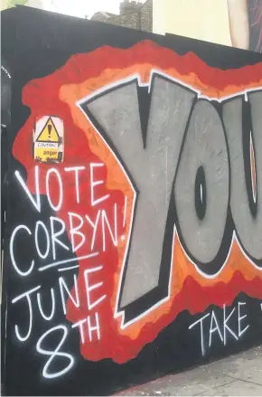  ??  ?? > Graffiti in support of Jeremy Corbyn painted on a hoarding board in