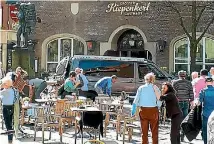  ?? PHOTO: AP ?? People stand in front of a restaurant in Munster, Germany, after a vehicle crashed into a crowd killing three people and injuring 20 others.