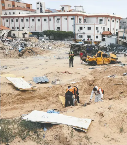  ?? AFP VIA GETTY IMAGES ?? Workers at the mass grave found near the Nasser Medical Complex in the Gaza Strip on Thursday.