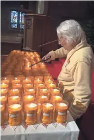  ?? BRUCE VIELMETTI / MILWAUKEE JOURNAL ?? Sister Rose Stietz lights candles for Milwaukee’s 2017 homicide victims at Our Savior’s Lutheran Church on Saturday.
