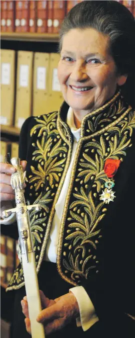  ??  ?? In this March 18, 2010 file photo, Simone Veil, dressed in the French Academicia­n’s uniform, displays her ceremonial sword in the library of the Institut de France before a ceremony in Paris.