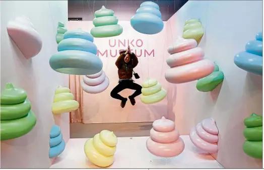  ?? — Reuters ?? Turd-tally awesome A visitor jumping to pose for a photo behind a display at the Unko (‘poop’ in Japanese) museum in Yokohama, Japan. The museum is trying to clean up people’s negative impression of faeces with what it calls the world’s first exhibition of cute and colourful poop.