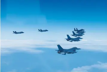  ?? South Korea Defense Ministry via AP ?? ■ In this photo provided by South Korea Defense Ministry, U.S. and South Korea Air Force fighter jets fly in formation during a joint drill on Tuesday. The South Korean and U.S. militaries flew 20 fighter jets over South Korea’s western sea Tuesday in a continued show of force as a senior U.S. official warned of a forceful response if North Korea goes ahead with its first nuclear test explosion in nearly five years.