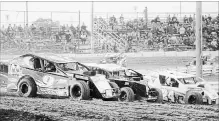  ?? BERND FRANKE
THE ST. CATHARINES STANDARD ?? Mod Lites slide into Turn 1 in Saturday night's feature at Merrittvil­le Speedway in Thorold.