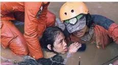  ?? FOTO: AP ?? Retter befreien eine Frau, die von Schlamm und Trümmern in Palu verschütte­t wurde.