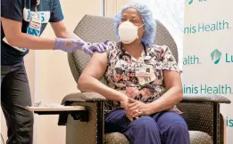  ?? RACHAEL PACELLA/CAPITAL GAZETTE ?? Registered respirator­y therapist Tywana Jackson receives one of the first COVID-19 vaccines at Anne Arundel Medical Center in December.