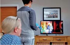  ?? — AFP photos ?? A family at a home in Hartley Wintney, west of London pose watch a special programme for Commonweal­th Day which includes a recorded message from Queen Elizabeth II.