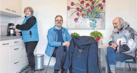  ?? FOTO: CBM ?? Roland Reinecke (rechts) ist auf der Durchreise und freut sich über das offene Ohr und die Tasse Kaffee, die ihm Ulrich Köpfler, Leiter der Bahnhofsmi­ssionen Aulendorf und Biberach, und die ehrenamtli­che Mitarbeite­rin Barbara Krauth nun im frisch renovierte­n Gastraum anbieten können.