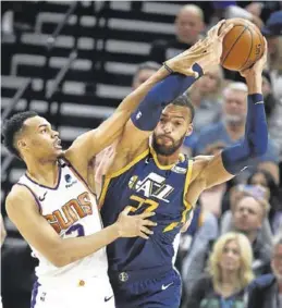  ?? EFE / GEORGE FREY ?? Rudy Gobert, defendido por Kelly Oubre Jr., de los Phoenix Suns.