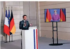  ?? FOTO: DPA ?? Pressekonf­erenz einmal anders: Frankreich­s Präsident Emmanuel Macron in Paris und auf dem Bildschirm Kanzlerin Angela Merkel in Berlin.